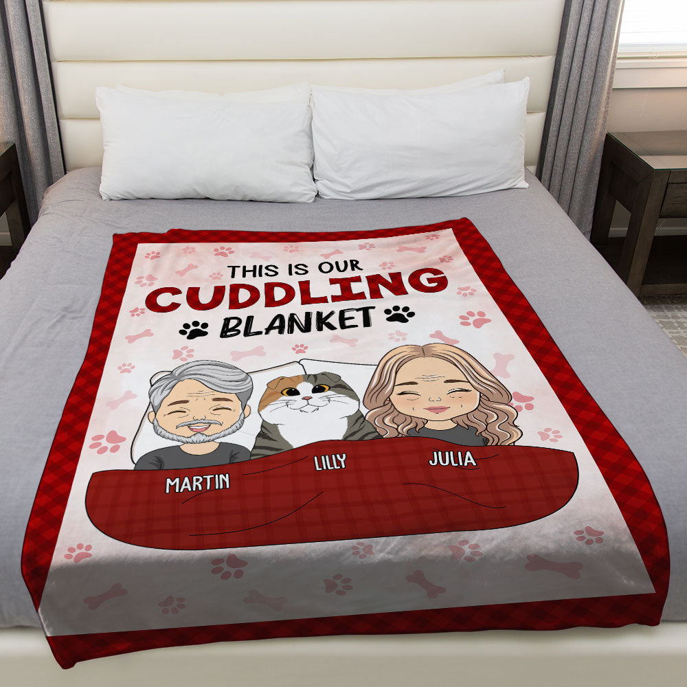 Personalized couple cuddling blanket with cartoon couple and dog, reads 'THIS IS OUR CUDDLING BLANKET' on red fleece blanket.