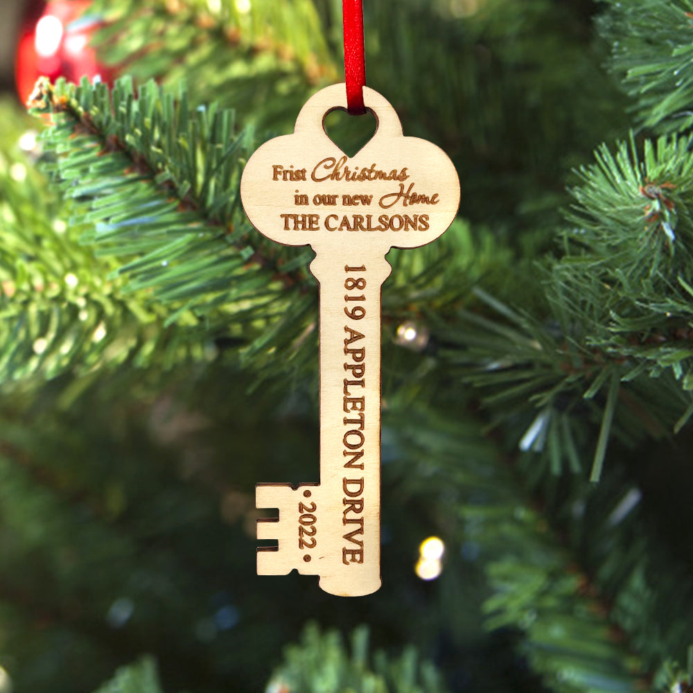 Personalized wooden key Christmas ornament for new home, with custom text on a red ribbon, perfect housewarming gift.